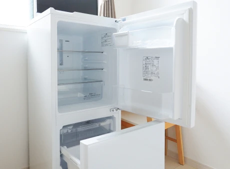 Isang kuwartong may kama, refrigerator at desk