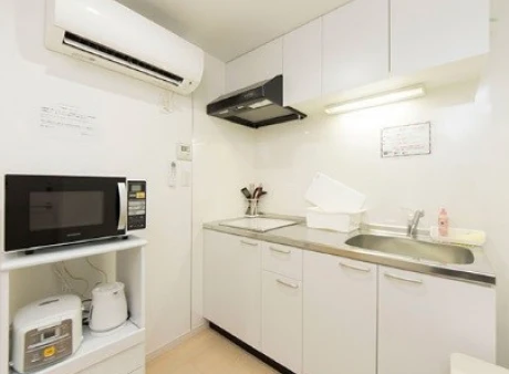 Isang kuwartong may kama, refrigerator at desk